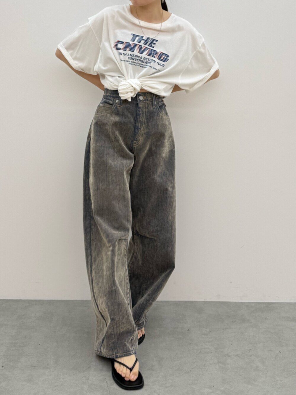ブラック系のサンダル、ホワイト系のTシャツ/カットソー、ベージュ系のデニムパンツを着用したレディースの夏コーディネートの5枚目の写真