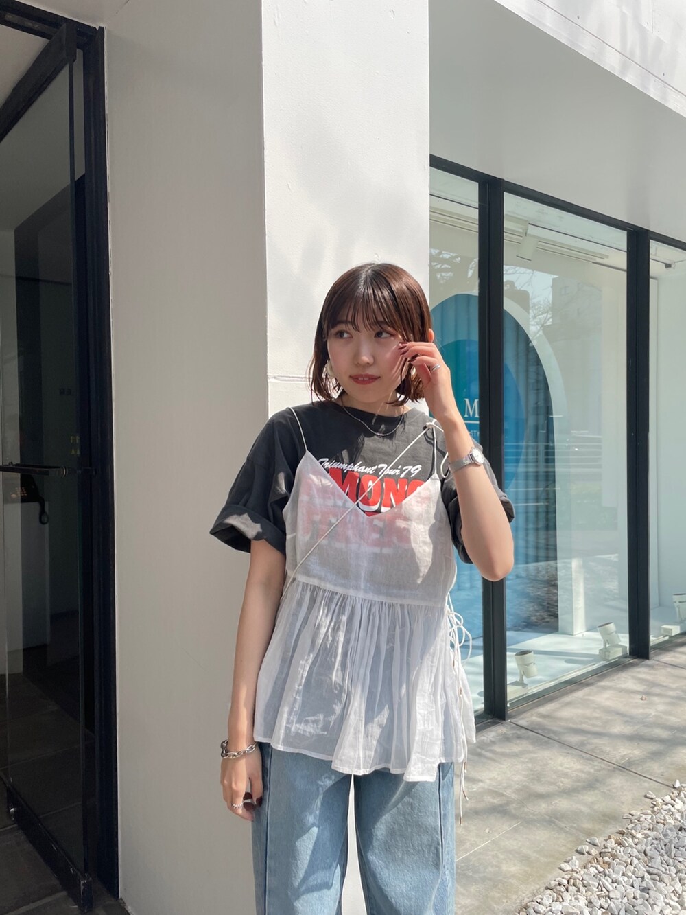 ブルー系のデニムパンツ、グレー系のTシャツ/カットソー、ホワイト系のショルダーバッグを着用したレディースの春コーディネートの2枚目の写真