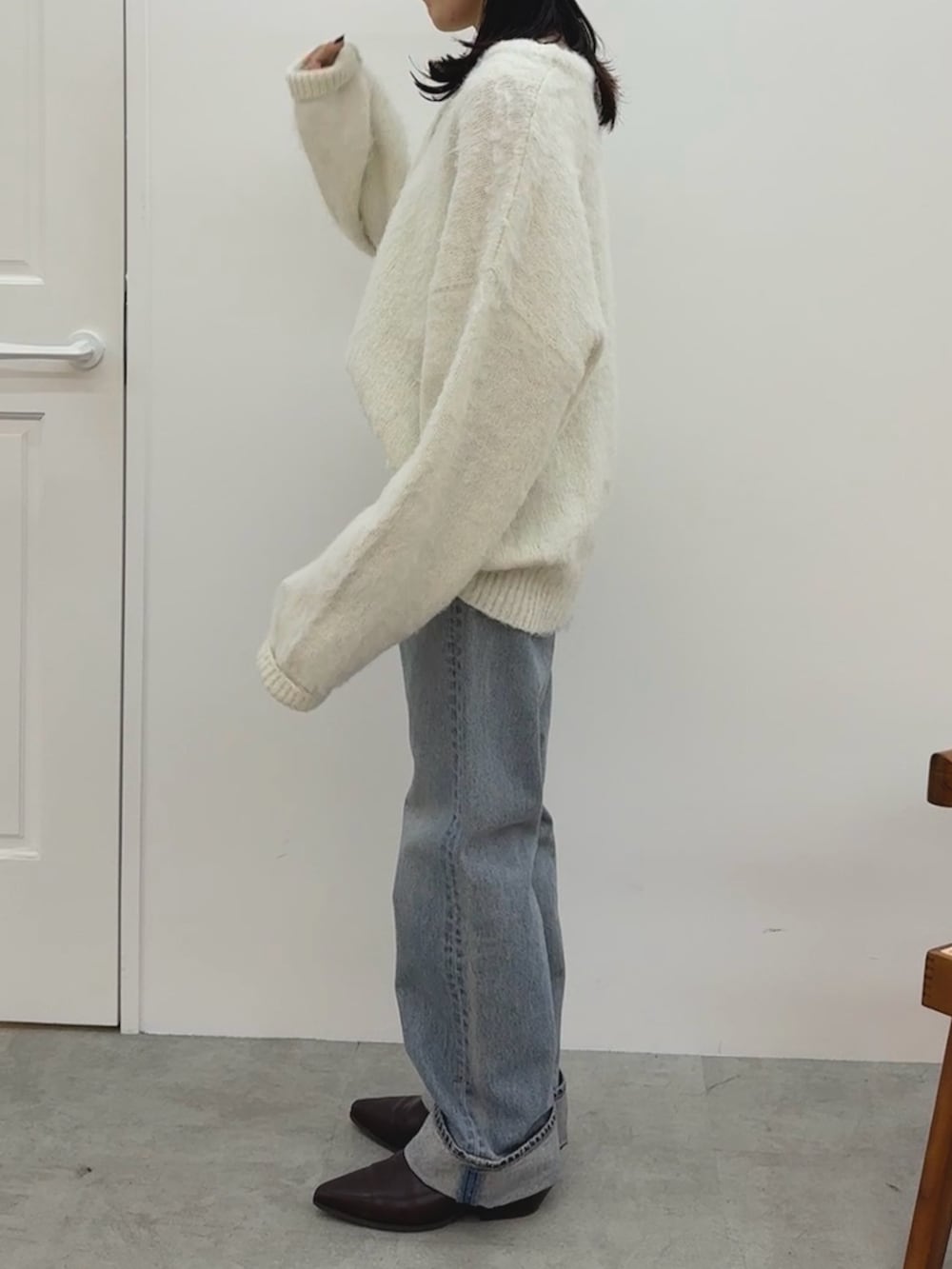 ホワイト系のニット/セーター、ブルー系のデニムパンツ、ブラウン系のブーツを着用したレディースの冬コーディネートの4枚目の写真