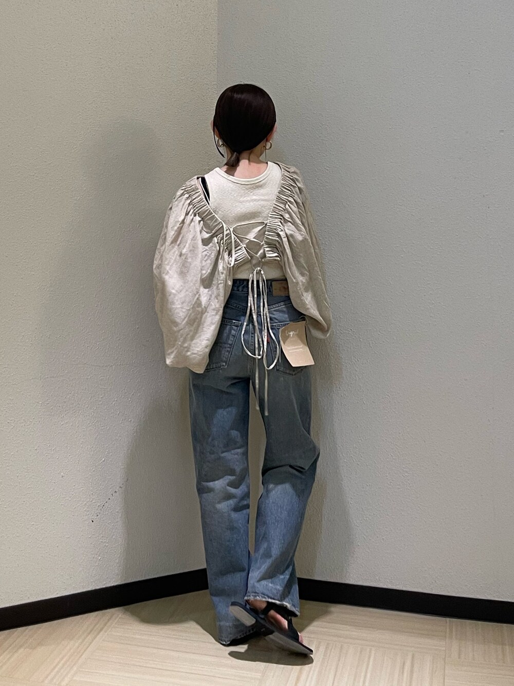 ベージュ系のシャツ/ブラウス、ブルー系のデニムパンツ、ブラック系のサンダルを着用したレディースの春コーディネートの3枚目の写真