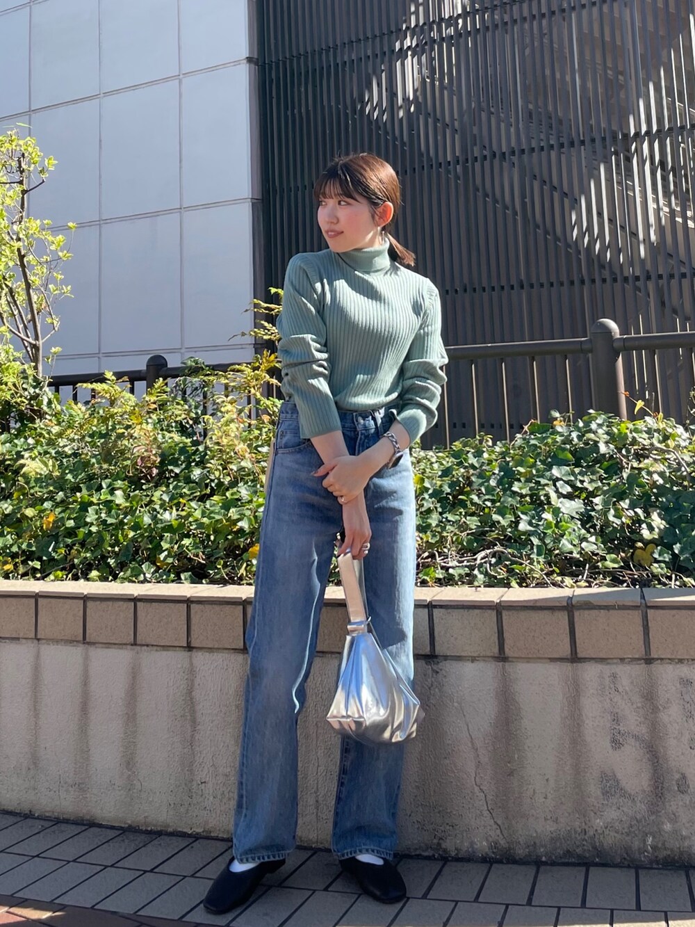 ブラウン系のブルゾン、ブラック系のパンプス、ブルー系のデニムパンツを着用したレディースの秋コーディネートの3枚目の写真