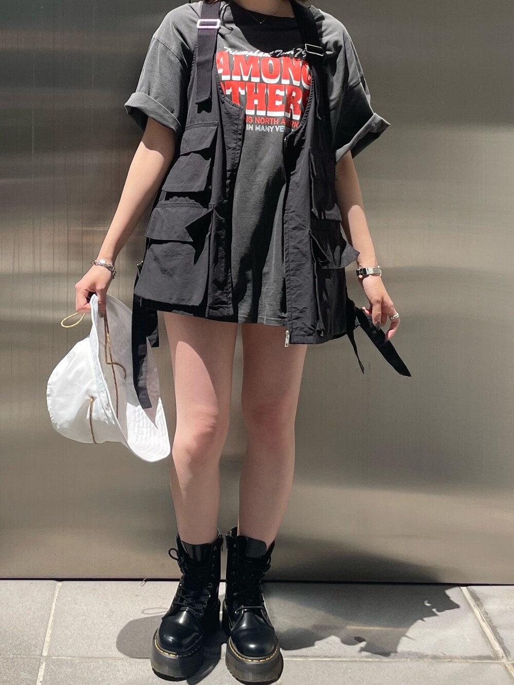 グレー系のTシャツ/カットソー、ブラック系のベスト、ホワイト系のハットを着用したレディースの春コーディネートの8枚目の写真
