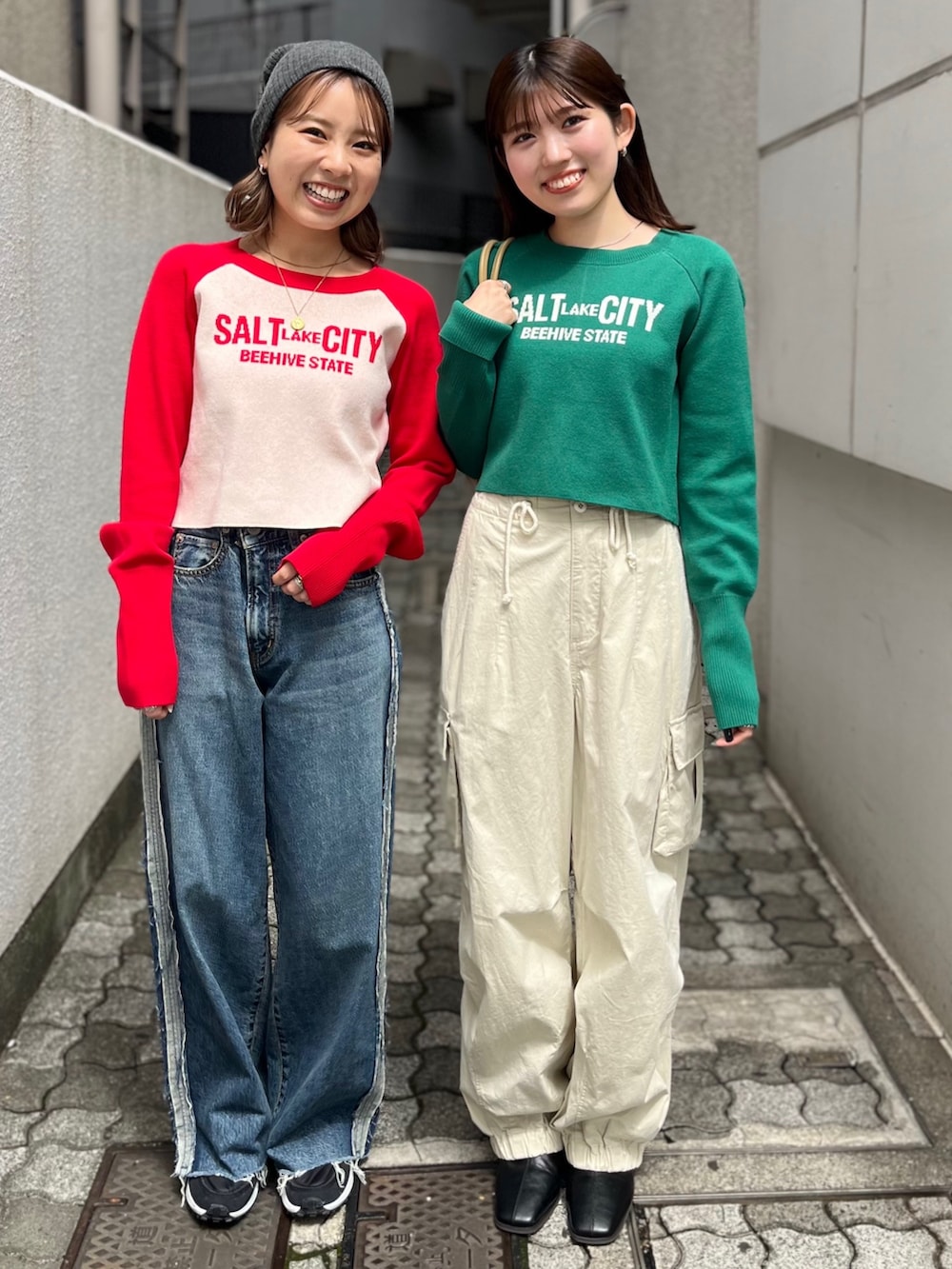 グリーン系のニット/セーター、ベージュ系のハンドバッグ、ブラック系のブーツを着用したレディースの秋コーディネートの2枚目の写真