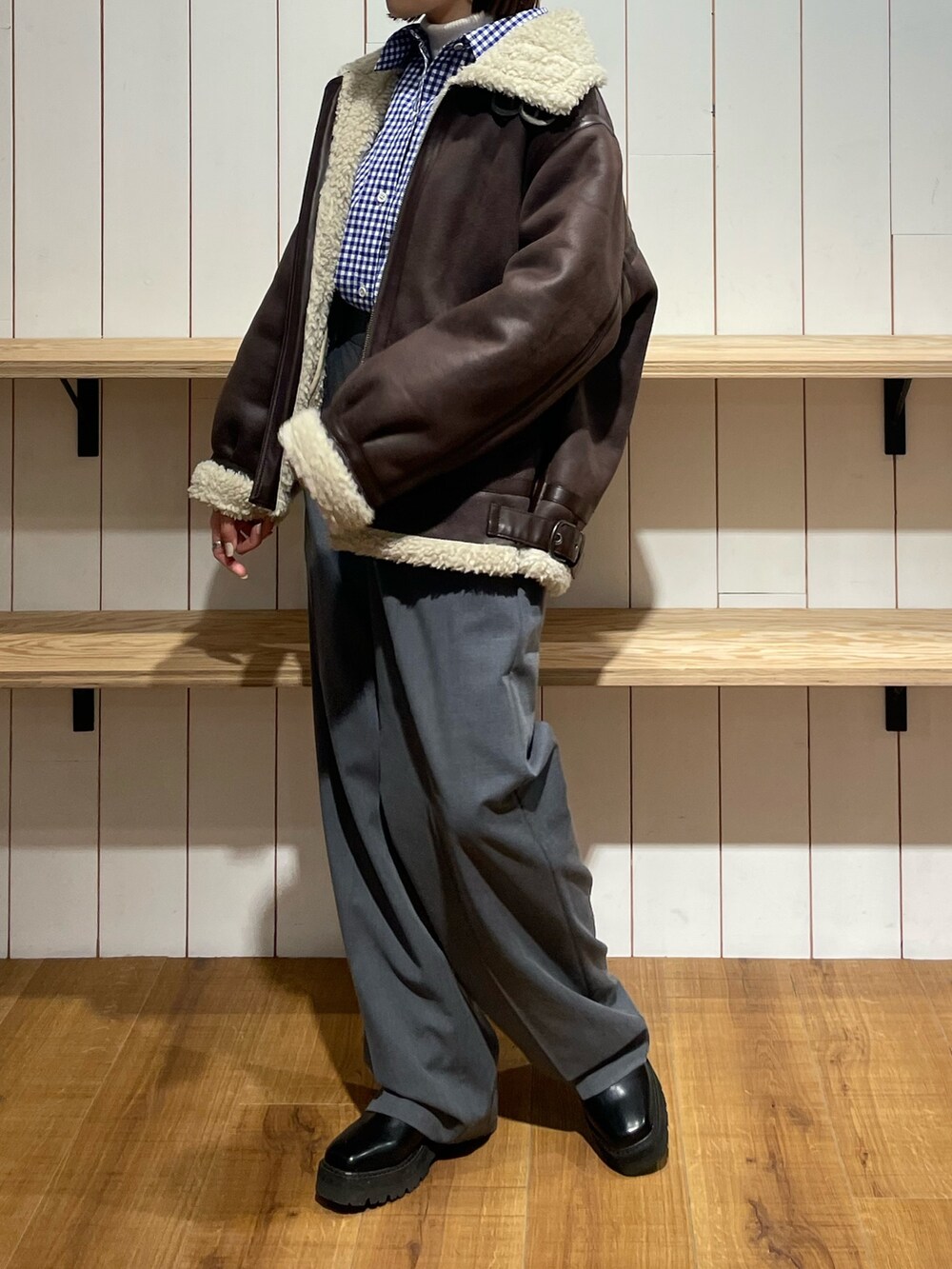 ブルー系のシャツ/ブラウス、ブラウン系のムートンコート、グレー系のその他パンツを着用したレディースの冬コーディネートの4枚目の写真