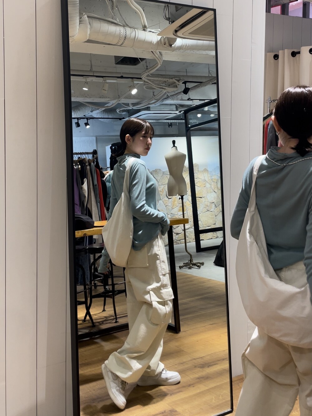 ホワイト系のカーゴパンツ、ホワイト系のショルダーバッグ、ブルー系のTシャツ/カットソーを着用したレディースの夏コーディネートの2枚目の写真