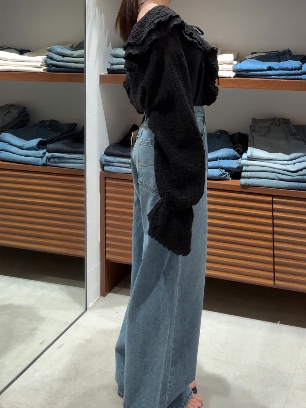 ブラック系のシャツ/ブラウス、ブルー系のデニムパンツを着用したレディースの春コーディネートの4枚目の写真