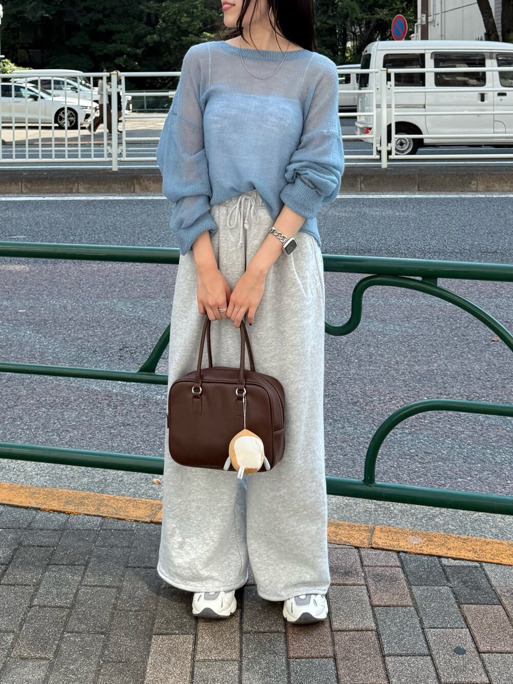 ブルー系のニット/セーター、ブラウン系のハンドバッグを着用したレディースの秋コーディネートの2枚目の写真