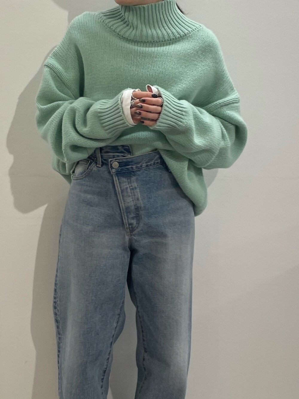 ブルー系のデニムパンツ、ブラック系のブーツ、ホワイト系のTシャツ/カットソーを着用したレディースの冬コーディネートの6枚目の写真