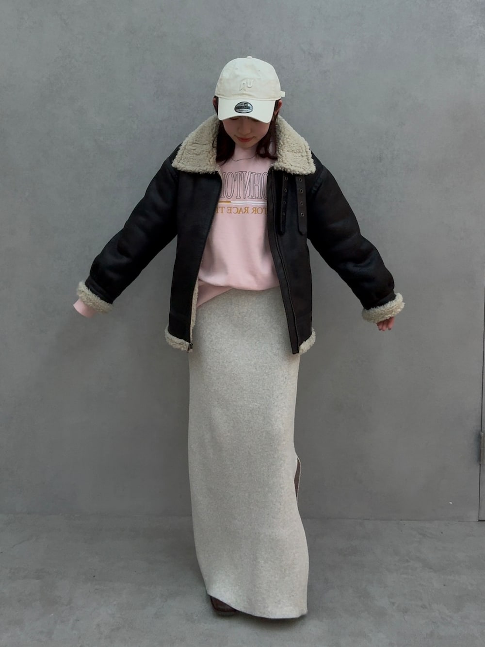 ピンク系のスウェット、グレー系のスカート、ブラウン系のブーツを着用したレディースの冬コーディネートの2枚目の写真