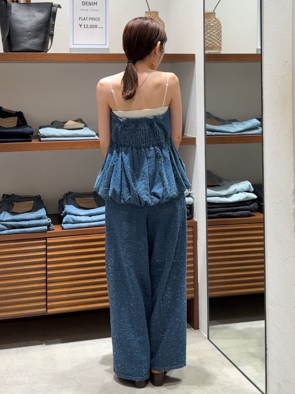 ブルー系のチューブトップ、ブルー系のデニムパンツ、その他のサンダルを着用したレディースの春コーディネートの2枚目の写真