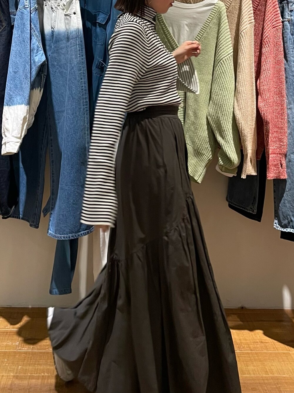 グレー系のスカート、ホワイト系のニット/セーター、シルバー系のショルダーバッグを着用したレディースの冬コーディネートの5枚目の写真