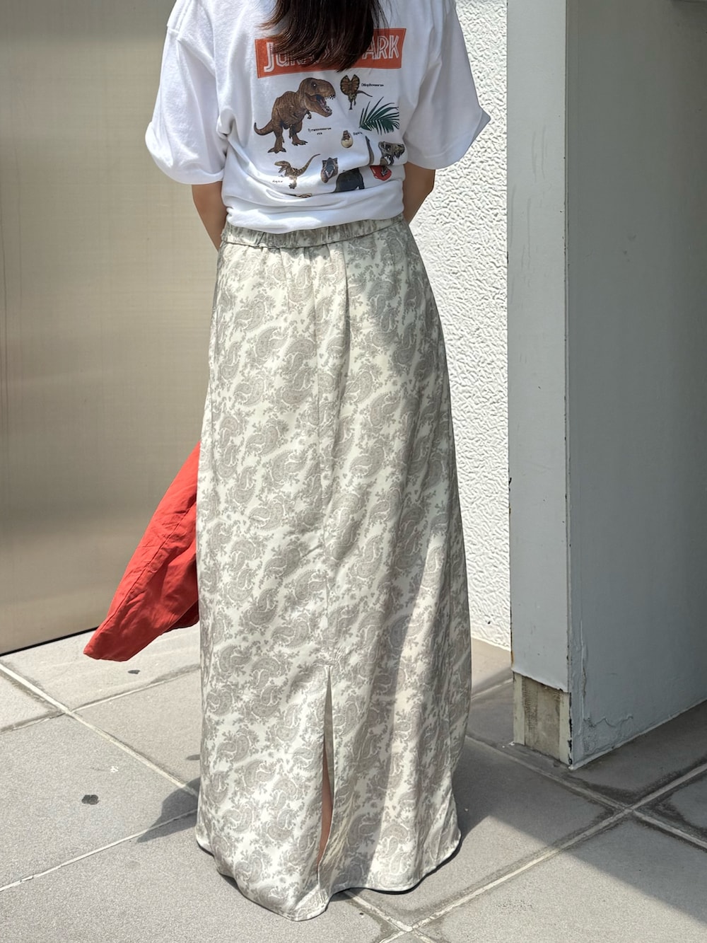 オレンジ系のトートバッグ、ホワイト系のTシャツ/カットソー、ブラック系のサンダルを着用したレディースの夏コーディネートの6枚目の写真