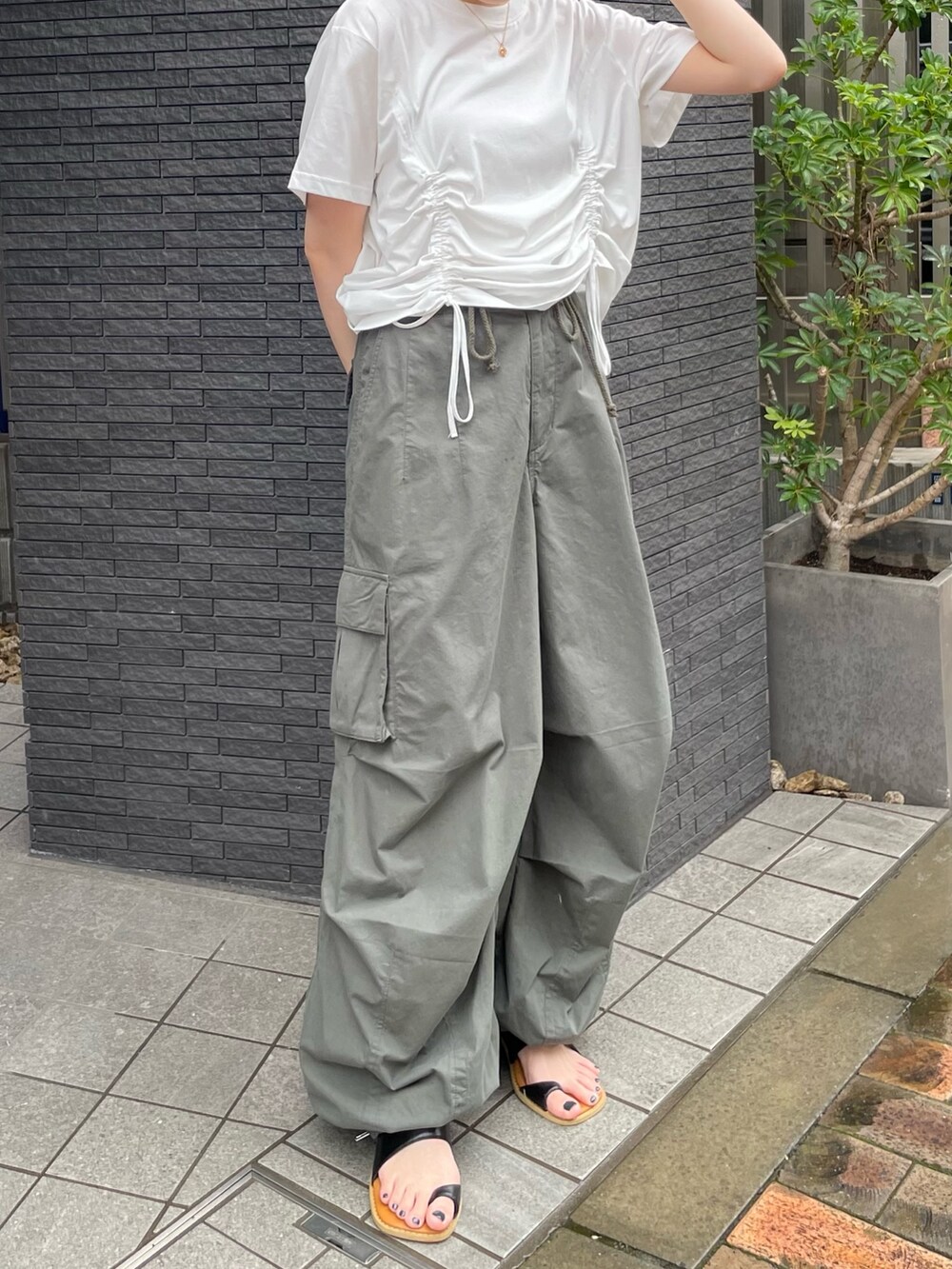 ホワイト系のTシャツ/カットソー、ブラック系のサンダル、グリーン系のカーゴパンツを着用したレディースの夏コーディネートの2枚目の写真