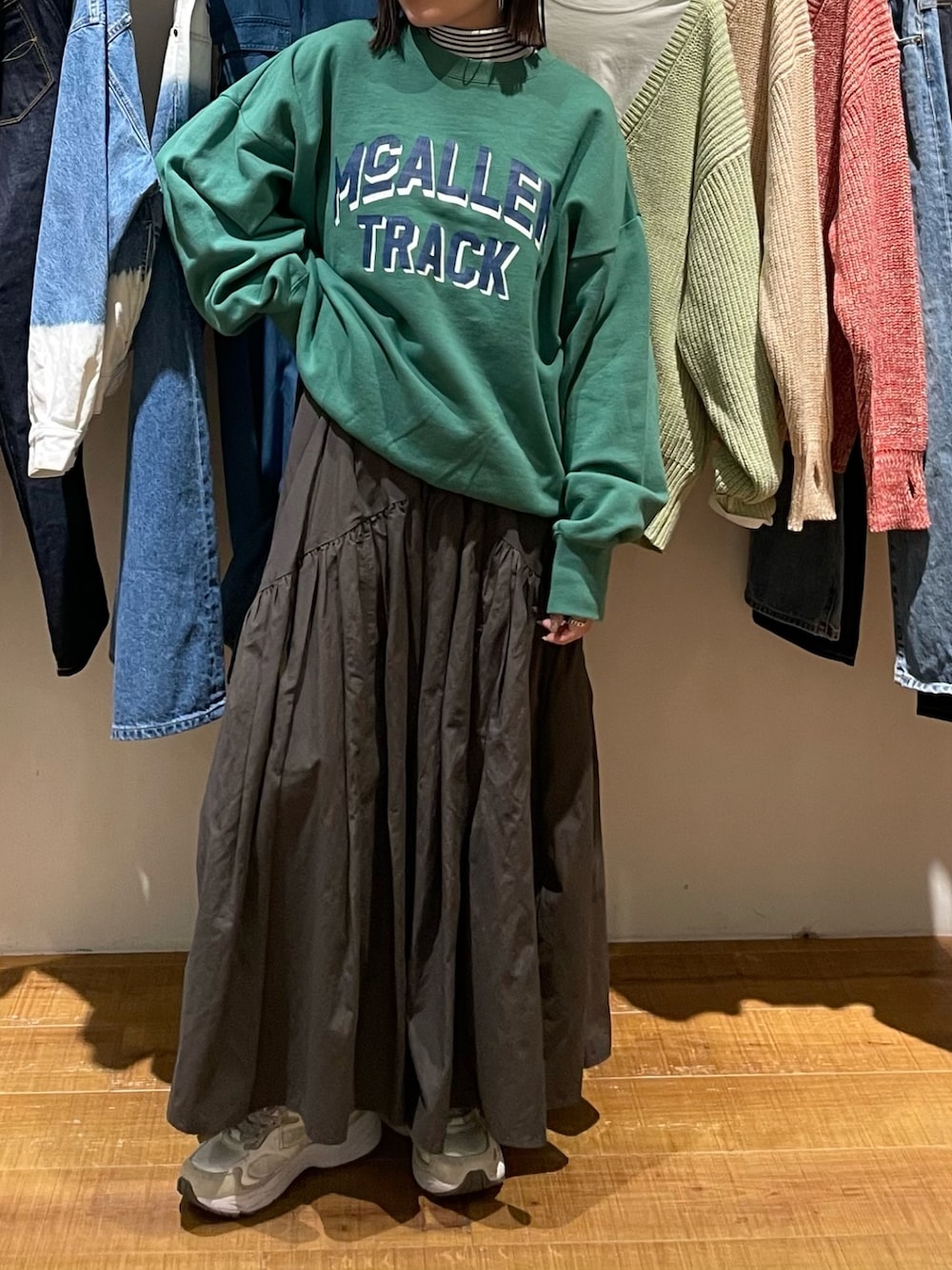 グレー系のスカート、グリーン系のスウェット、ホワイト系のニット/セーターを着用したレディースの冬コーディネートの2枚目の写真