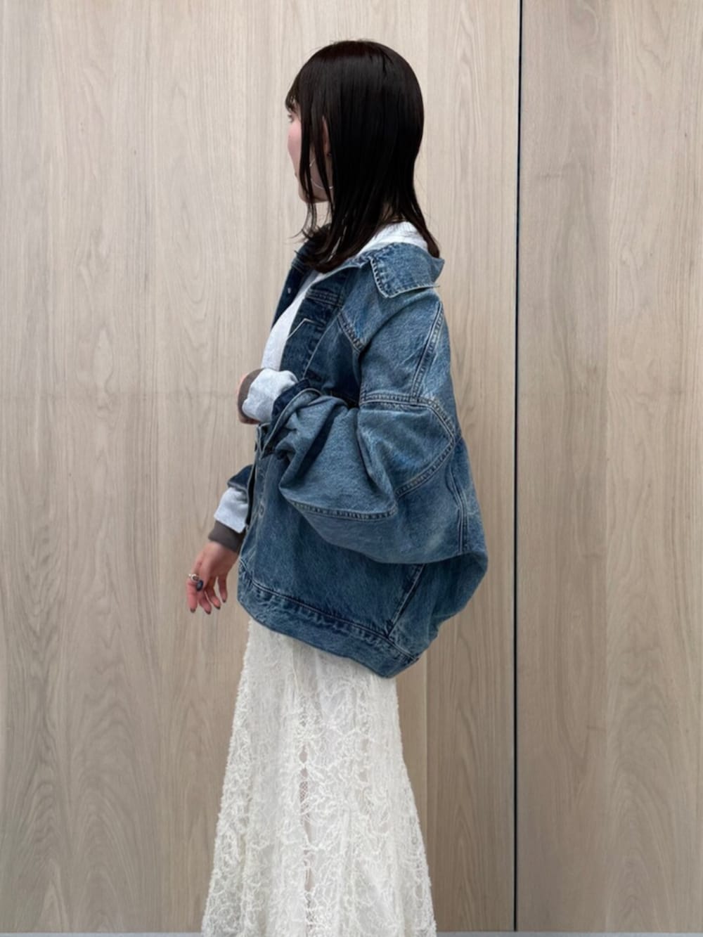 ホワイト系のスカート、ブルー系のデニムジャケット、グレー系のニット/セーターを着用したレディースの冬コーディネートの2枚目の写真