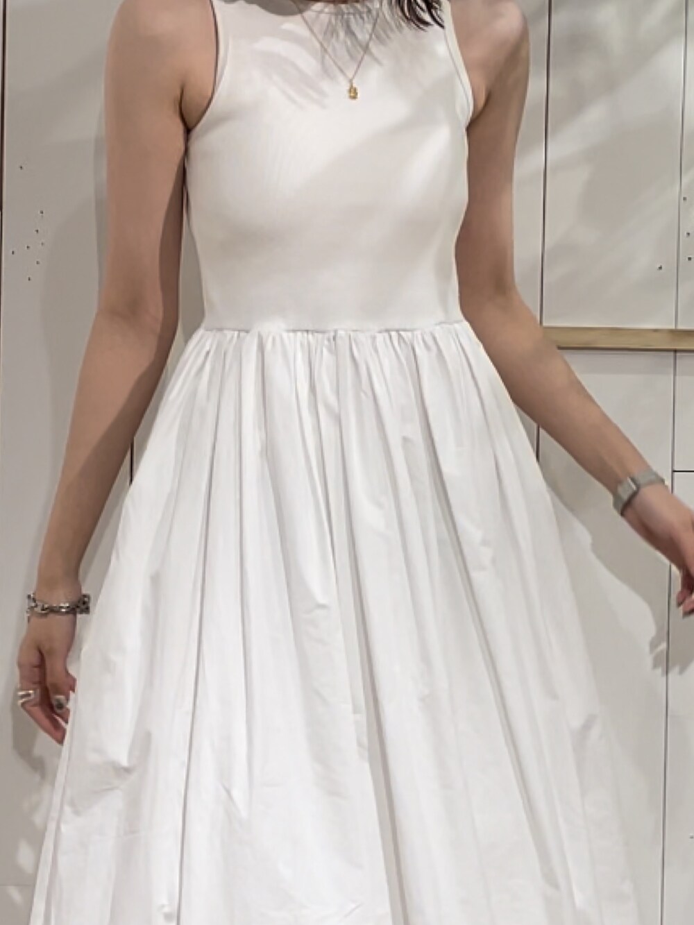 ホワイト系のワンピース、ゴールド系のネックレスを着用したレディースの夏コーディネートの6枚目の写真