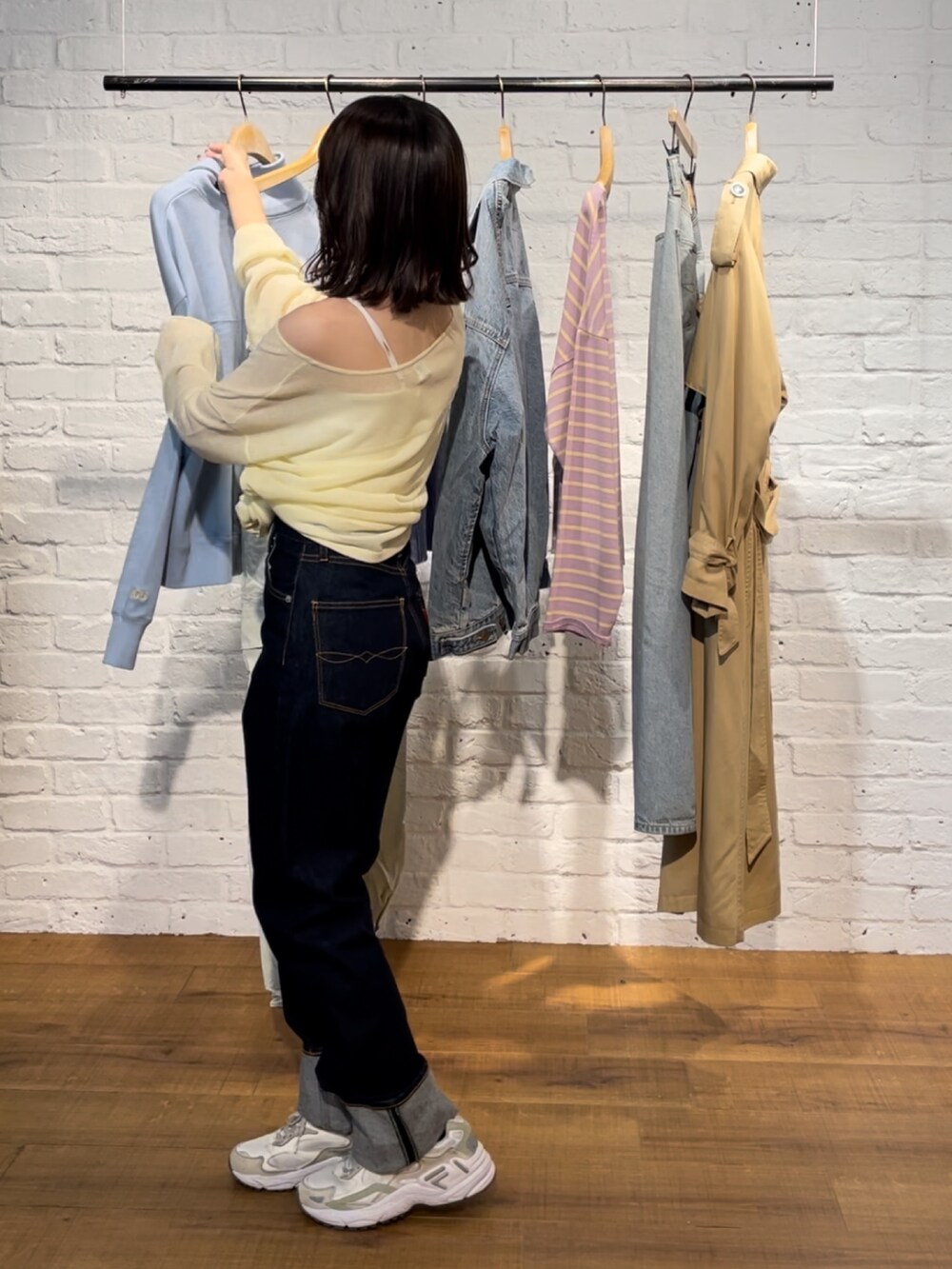 イエロー系のニット/セーター、ブルー系のデニムパンツを着用したレディースの春コーディネートの8枚目の写真