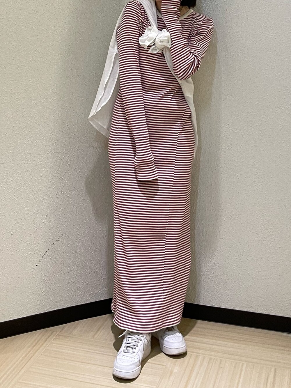 レッド系のワンピース、ホワイト系のシャツ/ブラウス、シルバー系のネックレスを着用したレディースの春コーディネートの4枚目の写真