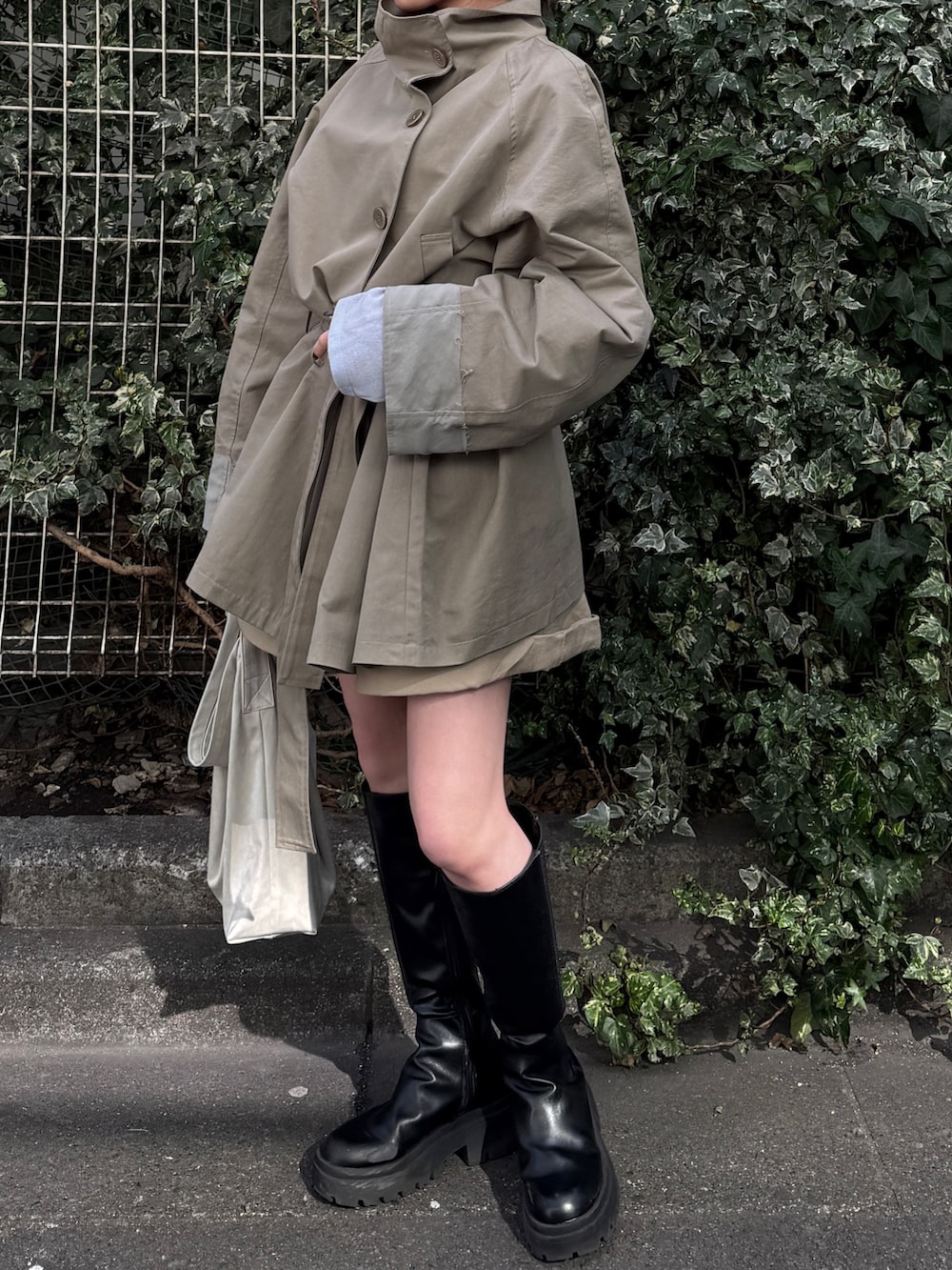 グリーン系のトレンチコート、ベージュ系のその他パンツを着用したレディースの冬コーディネートの4枚目の写真