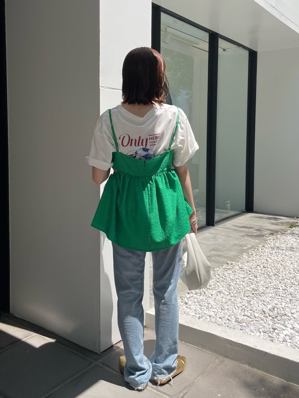 ホワイト系のハンドバッグ、ブルー系のデニムパンツ、グリーン系のシャツ/ブラウスを着用したレディースの春コーディネートの3枚目の写真