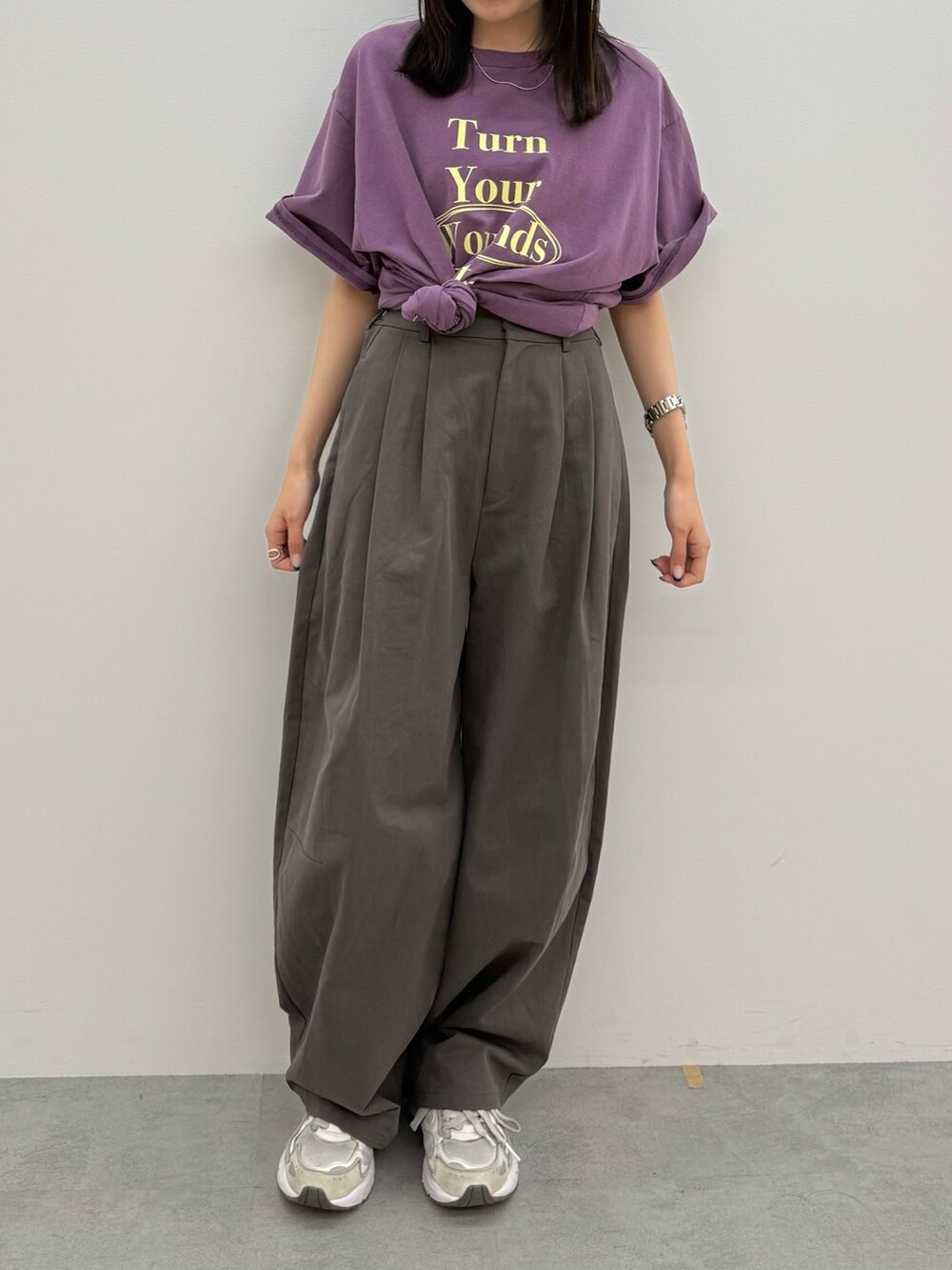 グレー系のチノパンツ、パープル系のTシャツ/カットソーを着用したレディースの春コーディネートの2枚目の写真