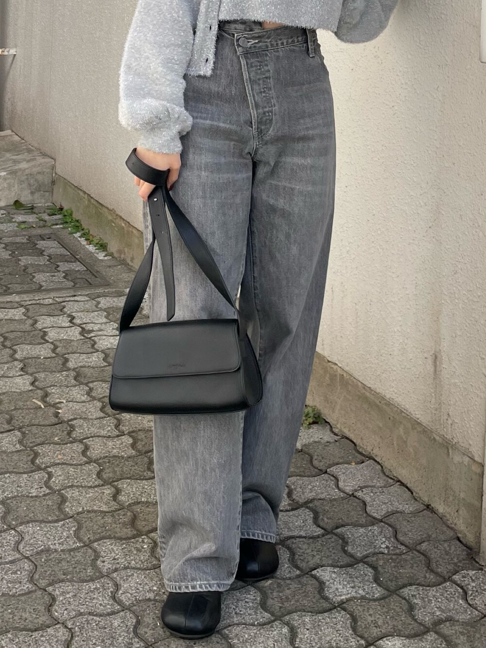 ブラック系のショルダーバッグ、ブラック系のブーツ、ブラック系のデニムパンツを着用したレディースの冬コーディネートの7枚目の写真