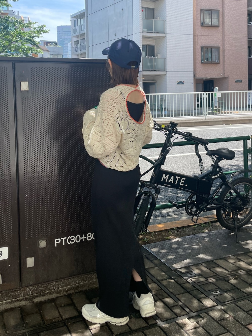 ブラック系のワンピース、ホワイト系のニット/セーター、ブルー系のキャップを着用したレディースの夏コーディネートの4枚目の写真