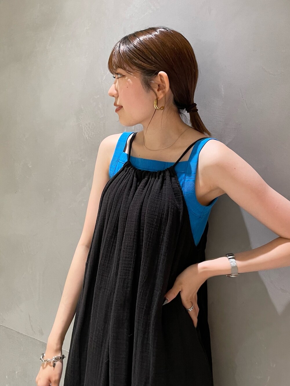 ブルー系のタンクトップ、ブラック系のワンピース、ブラック系のサンダルを着用したレディースの夏コーディネートの7枚目の写真