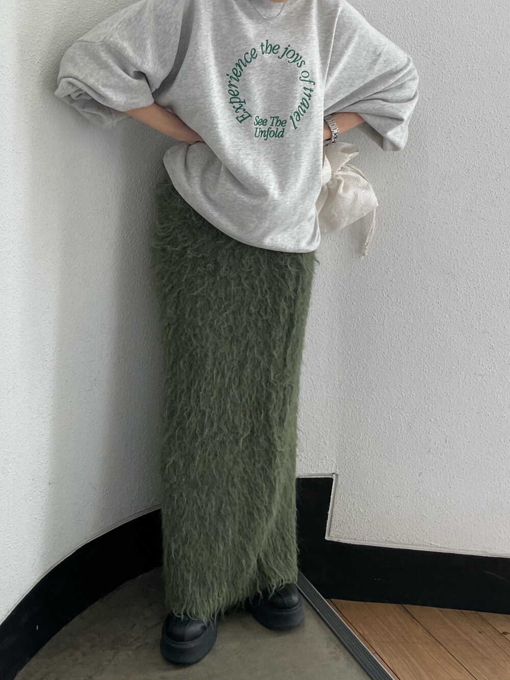 ホワイト系のハンドバッグ、ブラック系のブーツ、グレー系のスウェットを着用したレディースの秋コーディネートの7枚目の写真