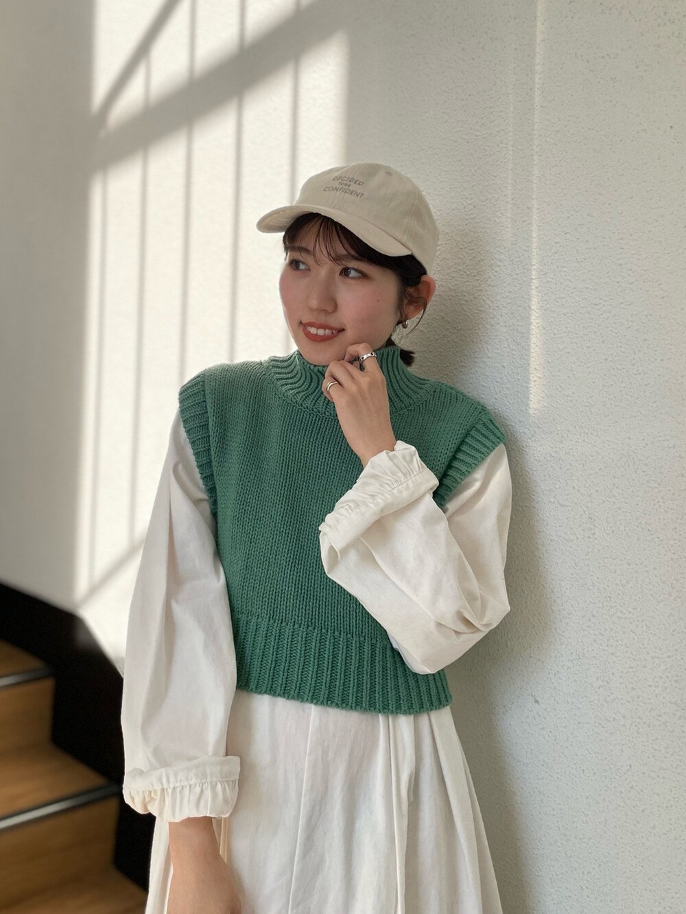 グリーン系のワンピース、ホワイト系のキャップを着用したレディースの春コーディネートの7枚目の写真
