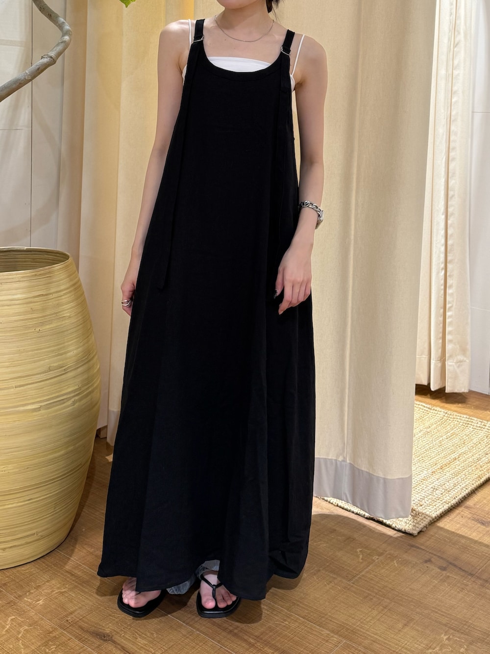 ブラック系のワンピース、ブルー系のデニムパンツ、ブラック系のサンダルを着用したレディースの夏コーディネートの7枚目の写真