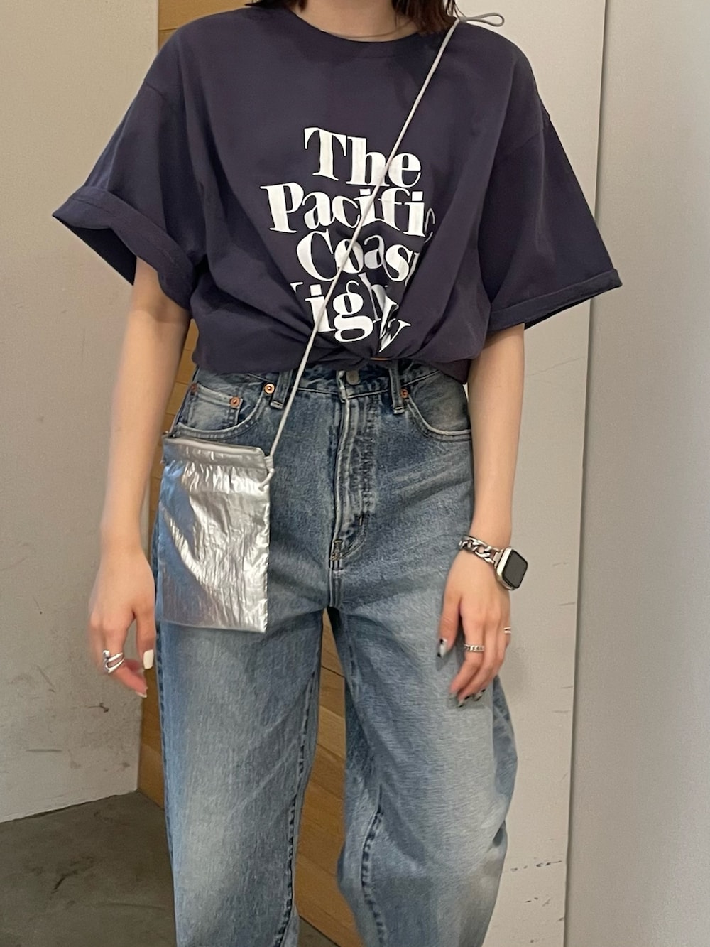 ホワイト系のサンダル、ブルー系のデニムパンツ、シルバー系のショルダーバッグを着用したレディースの春コーディネートの4枚目の写真