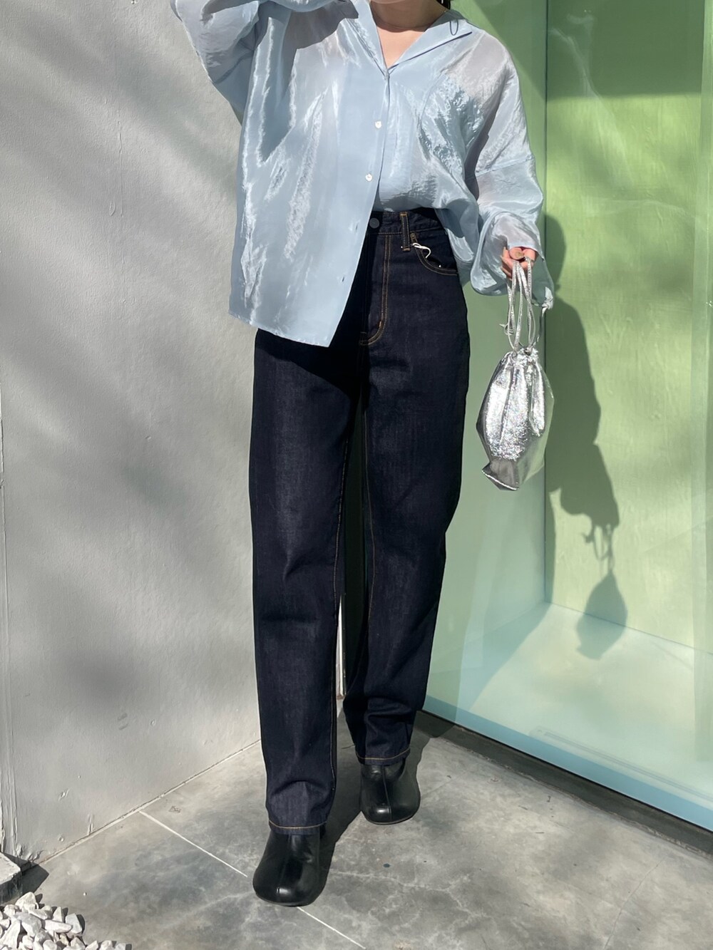 ブラック系のブーツ、ブルー系のデニムパンツ、ブルー系のシャツ/ブラウスを着用したレディースの冬コーディネートの2枚目の写真