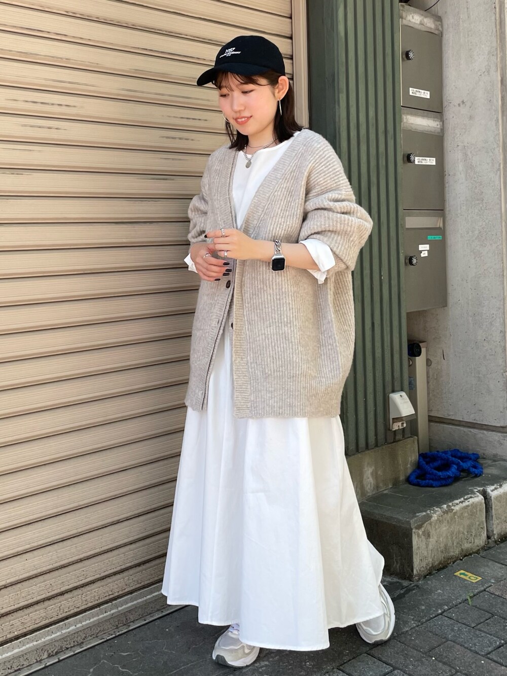 ホワイト系のカーディガン/ボレロ、ブラック系のワンピース、ブラック系のキャップを着用したレディースの秋コーディネートの2枚目の写真