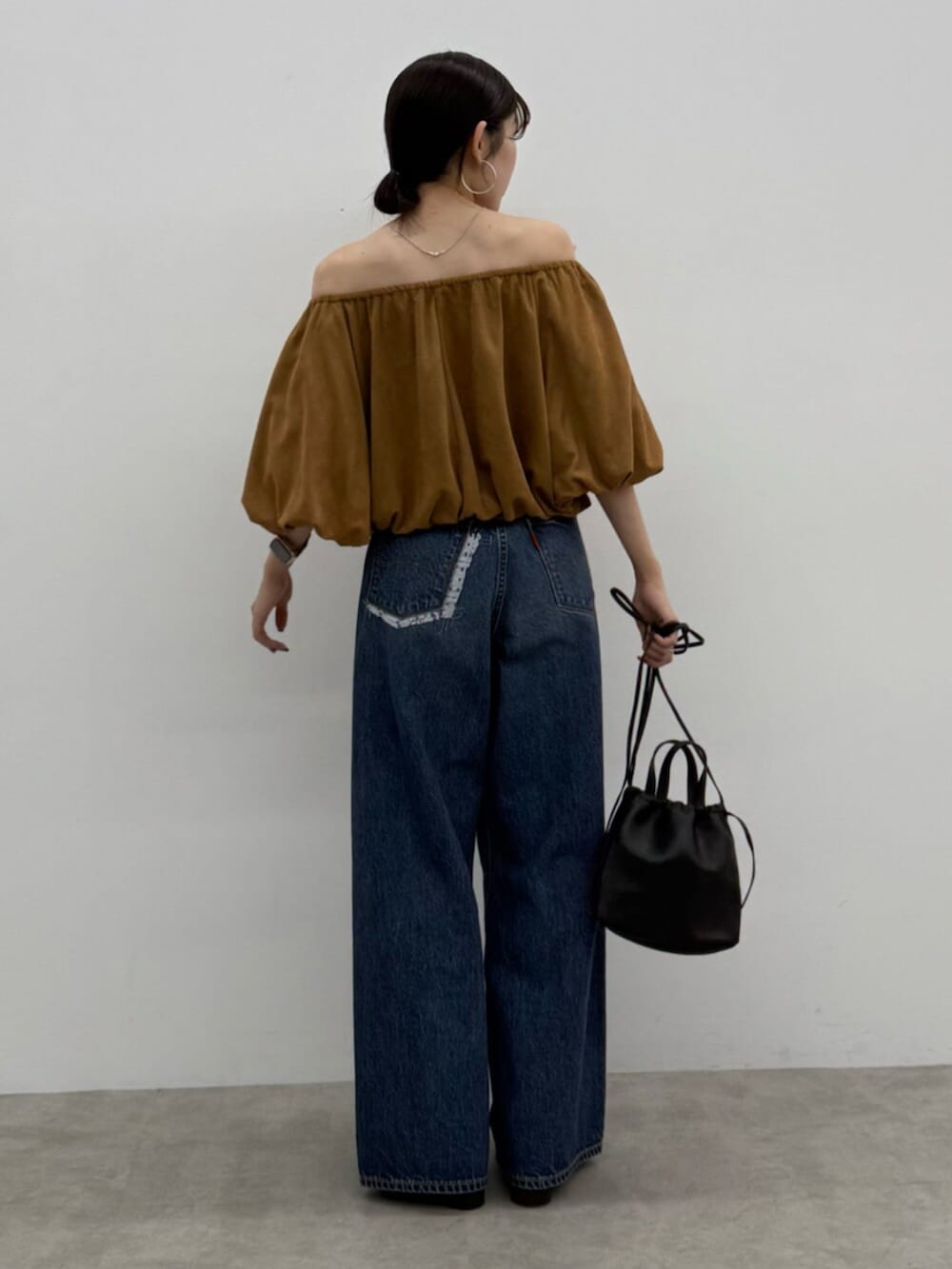 ブラウン系のブーツ、ブラック系のショルダーバッグ、ブルー系のデニムパンツを着用したレディースの秋コーディネートの5枚目の写真