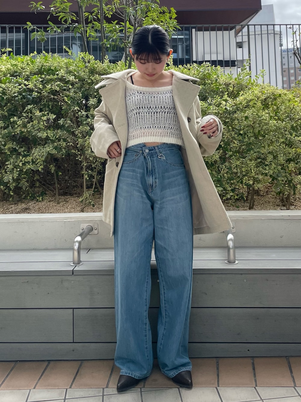 ブラック系のキャミソール、ブルー系のデニムパンツ、ブラック系のブーツを着用したレディースの秋コーディネートの2枚目の写真