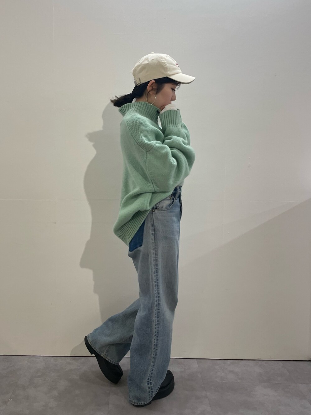 ブルー系のデニムパンツ、ブラック系のブーツ、ホワイト系のTシャツ/カットソーを着用したレディースの冬コーディネートの2枚目の写真