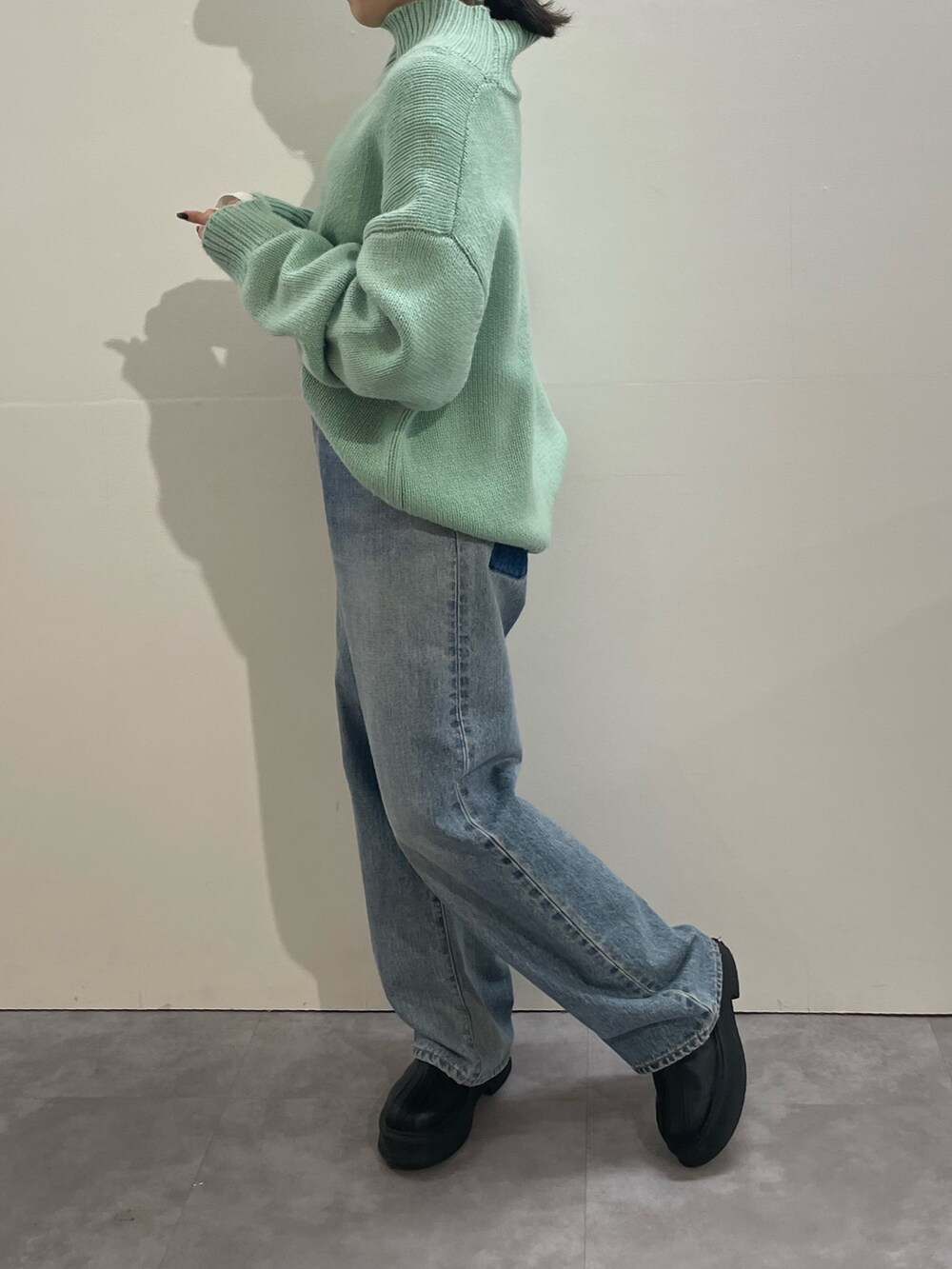 ブルー系のデニムパンツ、ブラック系のブーツ、ホワイト系のTシャツ/カットソーを着用したレディースの冬コーディネートの4枚目の写真