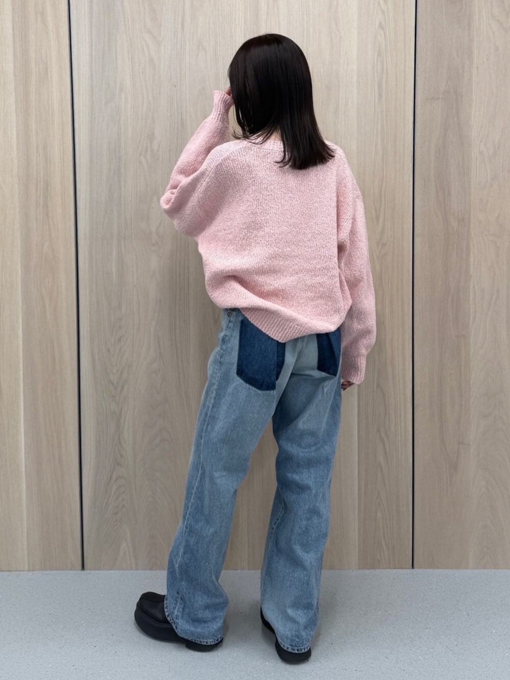 ブルー系のデニムパンツ、ピンク系のニット/セーター、ブラック系のブーツを着用したレディースの冬コーディネートの4枚目の写真