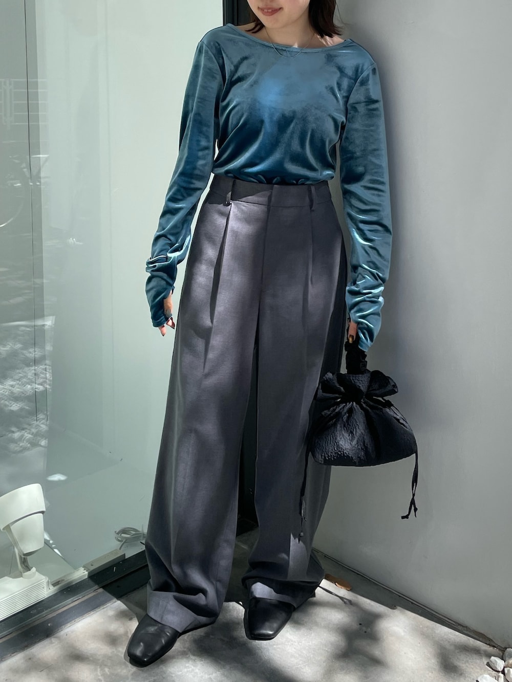 ブラック系のブーツ、ブラック系のハンドバッグ、ブルー系のTシャツ/カットソーを着用したレディースの秋コーディネートの4枚目の写真