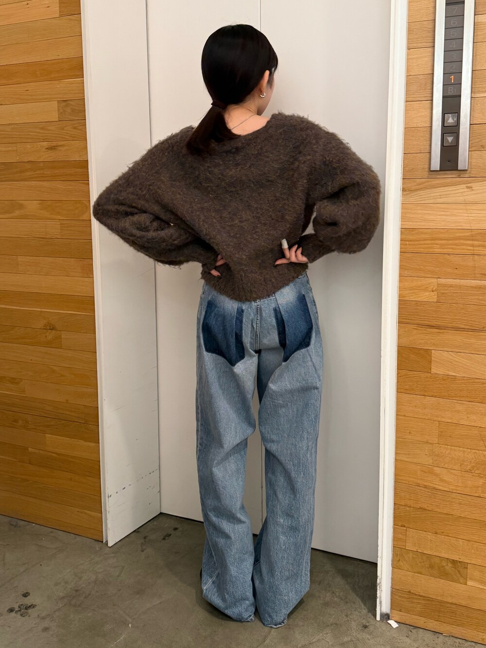ブルー系のデニムパンツ、ブラック系のブーツ、ブラウン系のカーディガン/ボレロを着用したレディースの冬コーディネートの4枚目の写真