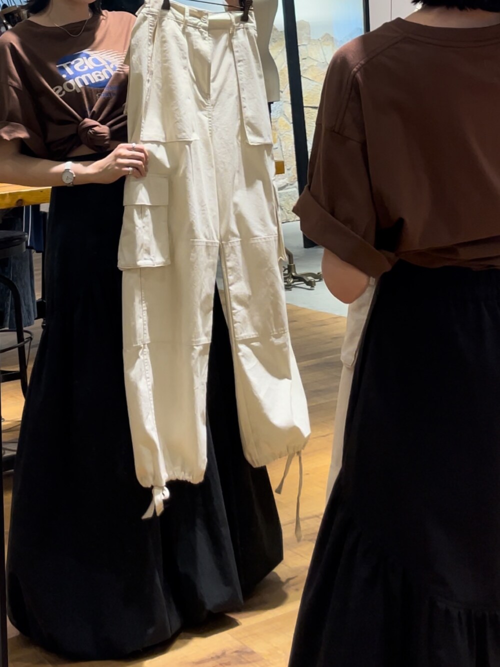 ブラック系のスカート、ブラウン系のTシャツ/カットソーを着用したレディースの夏コーディネートの2枚目の写真