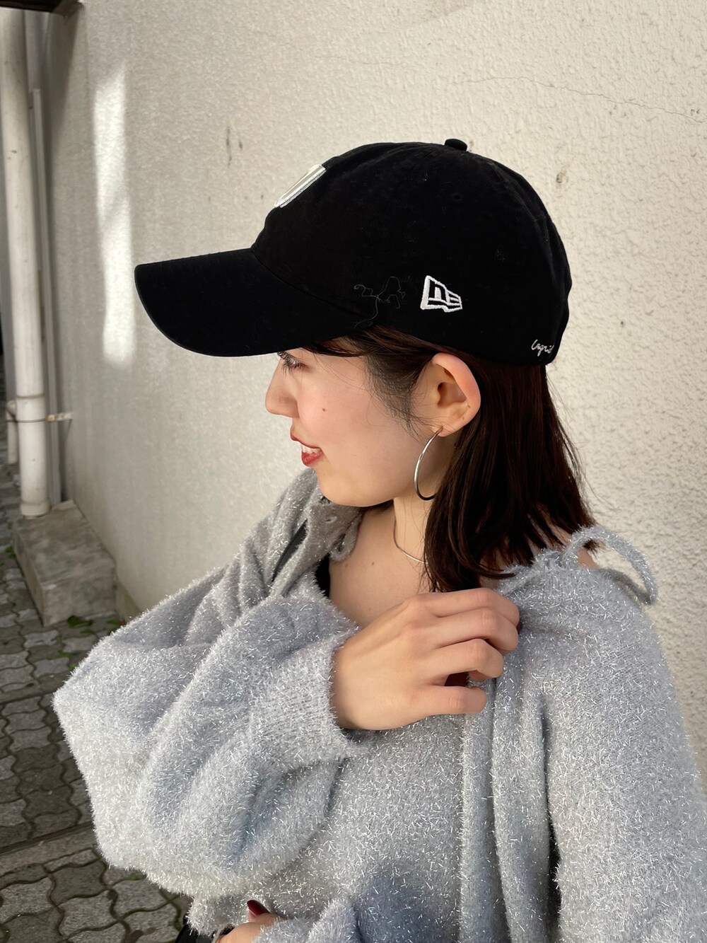 ブラック系のショルダーバッグ、ブラック系のブーツ、ブラック系のデニムパンツを着用したレディースの冬コーディネートの9枚目の写真