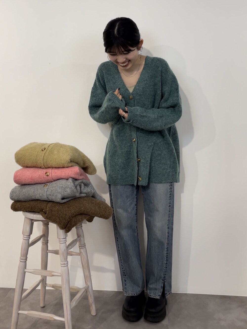ブルー系のデニムパンツ、ブラック系のブーツ、グリーン系のカーディガン/ボレロを着用したレディースの冬コーディネートの3枚目の写真