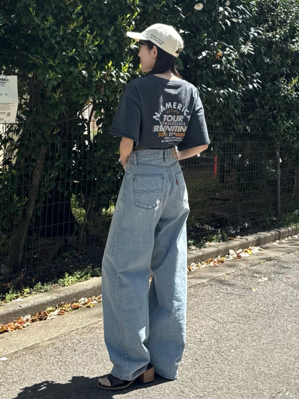 ブルー系のデニムパンツ、ブラック系のサンダル、グレー系のTシャツ/カットソーを着用したレディースの春コーディネートの4枚目の写真