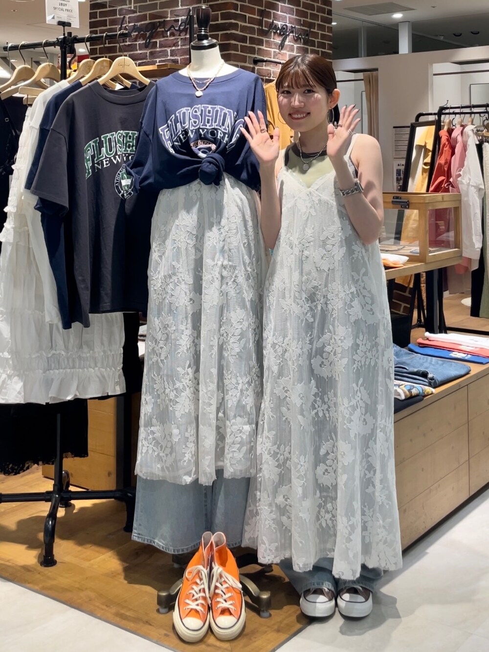 グリーン系のタンクトップ、ブルー系のデニムパンツ、ホワイト系のワンピースを着用したレディースの夏コーディネートの2枚目の写真