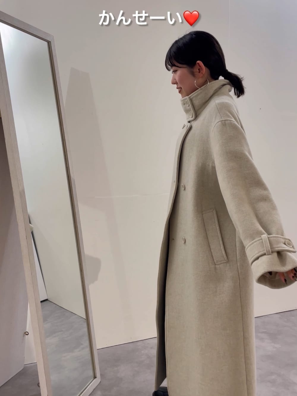 ブルー系のデニムパンツ、ブラック系のブーツ、レッド系のニット/セーターを着用したレディースの冬コーディネートの2枚目の写真