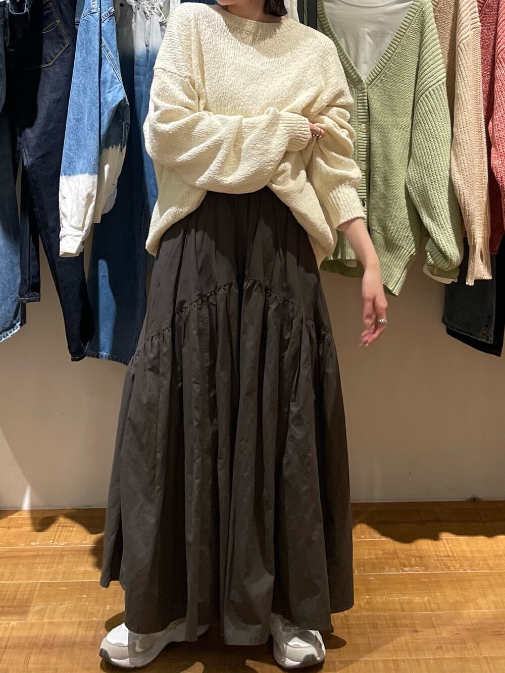 グレー系のスカート、ホワイト系のニット/セーター、ベージュ系のキャップを着用したレディースの冬コーディネートの2枚目の写真