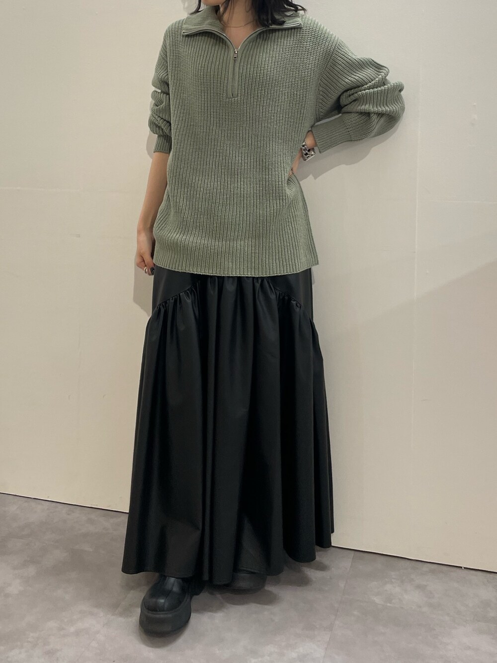 ブラック系のブーツ、ブラック系のスカート、グレー系のニット/セーターを着用したレディースの冬コーディネートの2枚目の写真