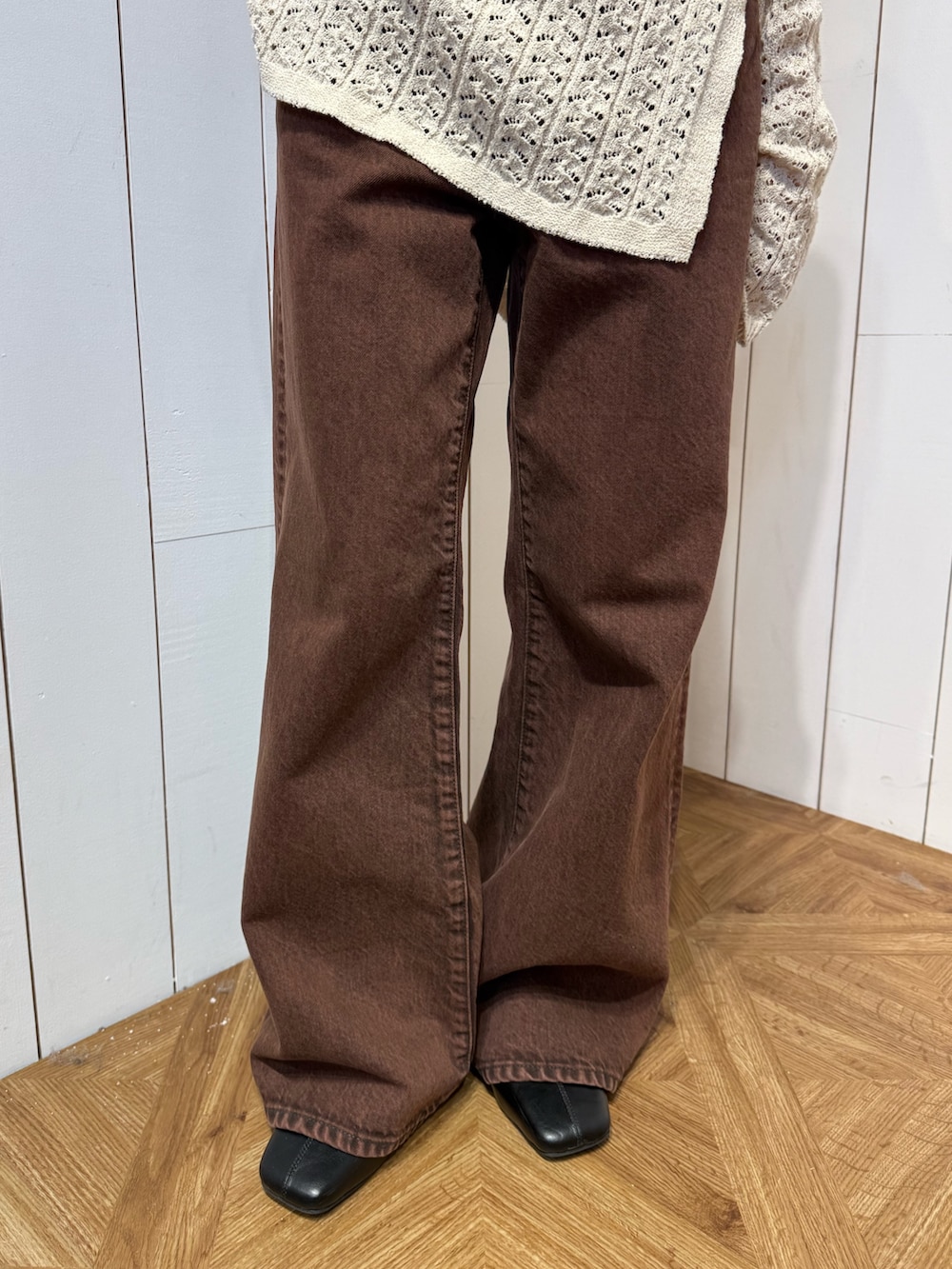 ブラウン系のデニムパンツ、ブラック系のサンダル、ベージュ系のニット/セーターを着用したレディースの春コーディネートの6枚目の写真